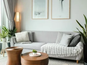 Whole-home remodel: a calm living room with a grey sofa, timber side tables and framed prints